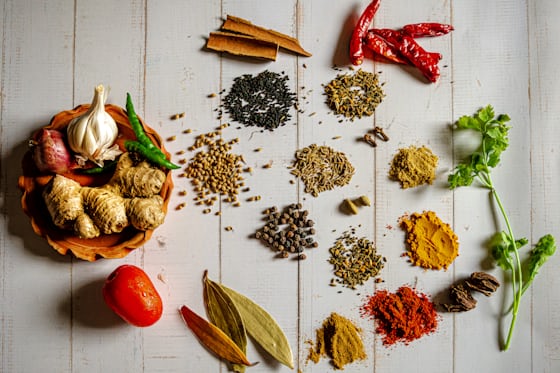 Assorted spices in small bowls on a wooden surface